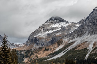 白雪皑皑、树木环绕的灰色山脉